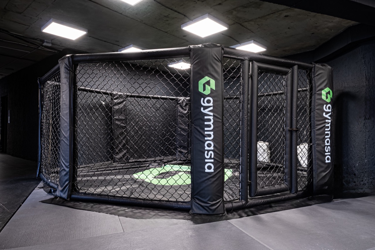 Training hall view with octagon cage beside the judo mats